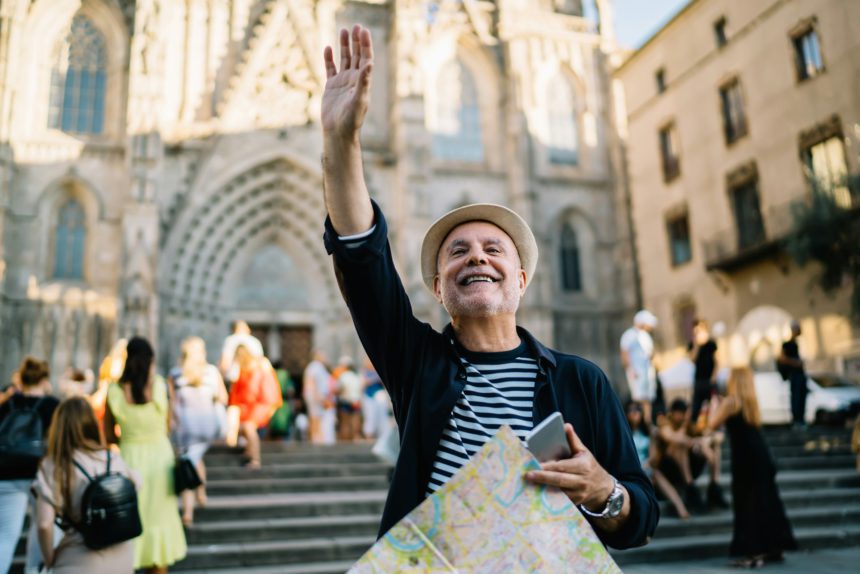 cheerful Caucaisan man gesturing hand during solo vacations