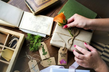 Hands diy wrapping gift box on wooden table