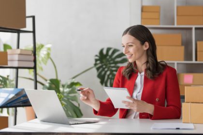 Portrait business woman smile and use tablet checking information on parcel shipping box