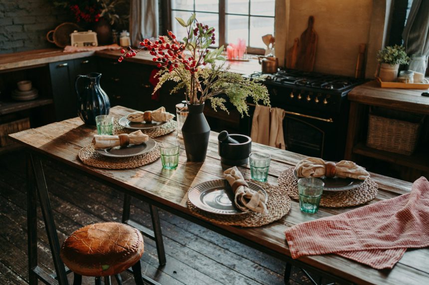 Table served for dinner. Cozy kitchen interior. Cultery and napkins on table for guests