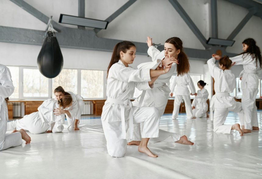 Teenage girls fighting at aikido training in martial arts school