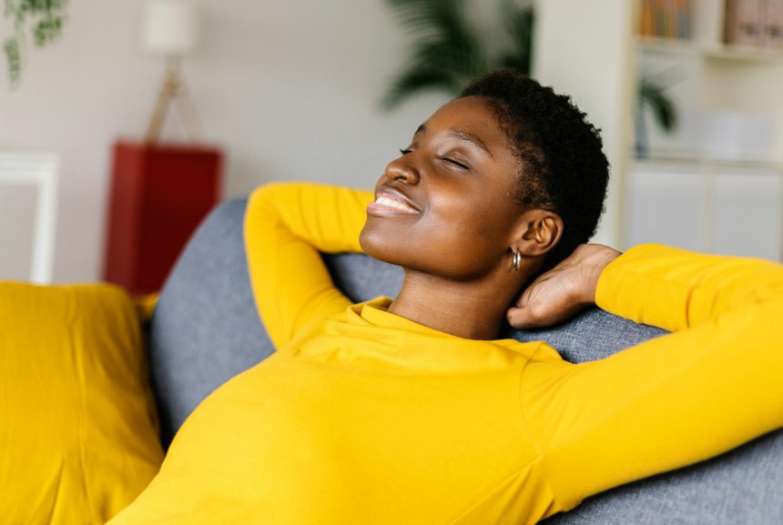 Young African American woman relaxing on a sofa at home.